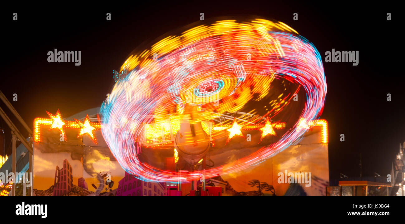 Autour des feux sur un carnival ride créer des stries rouge Banque D'Images