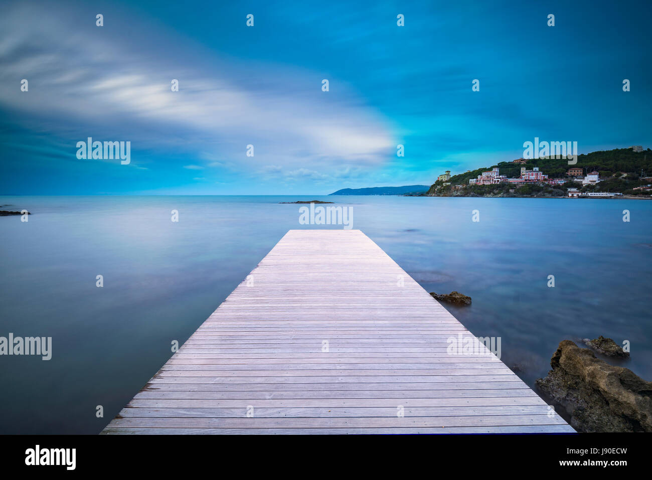 Castiglioncello destination, jetée en bois dans la baie, des rochers et de la mer sur le coucher du soleil. La Toscane, Italie, Europe. L'exposition longue Banque D'Images