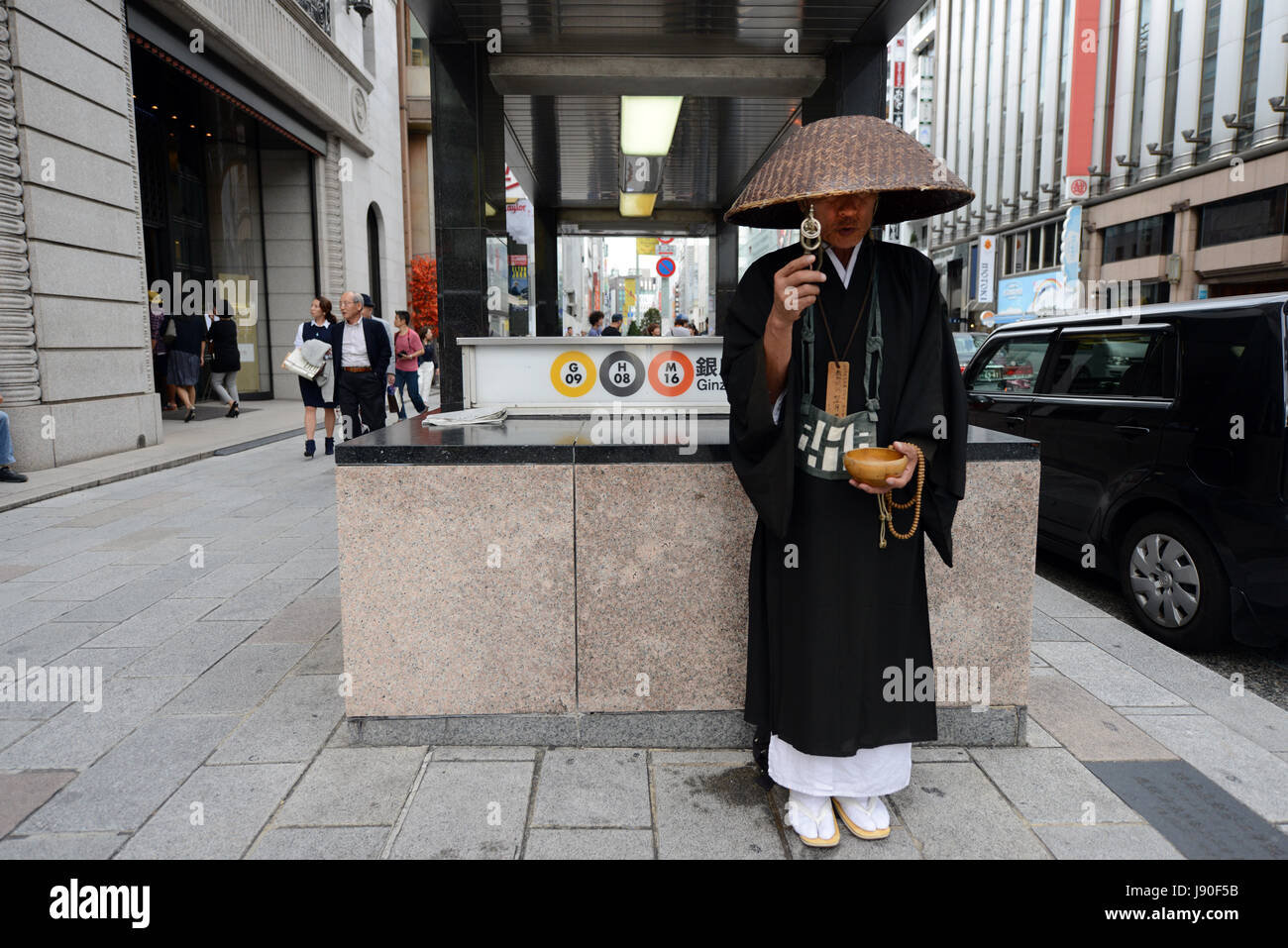 Un moine zen japonais ramassant l'aumône devant la station de métro Ginza à Tokyo, au Japon. Banque D'Images