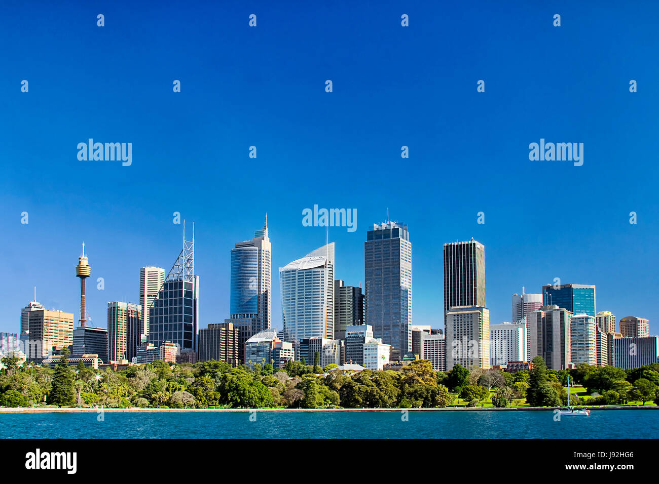 Ville de Sydney Central Business District skyline sur le Royal Botanic garden à travers les eaux cristallines de l'Harbour sous blue Clean Sky. Banque D'Images