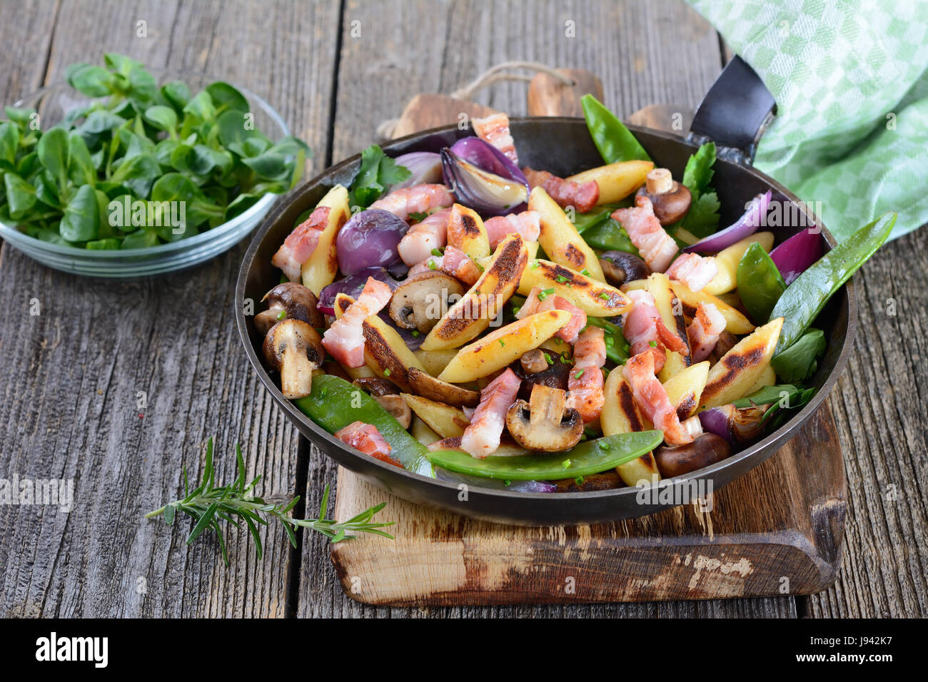 La forme de doigts frits bavarois beignets de pomme de terre avec légumes et lard fumé, mâche en salade Banque D'Images