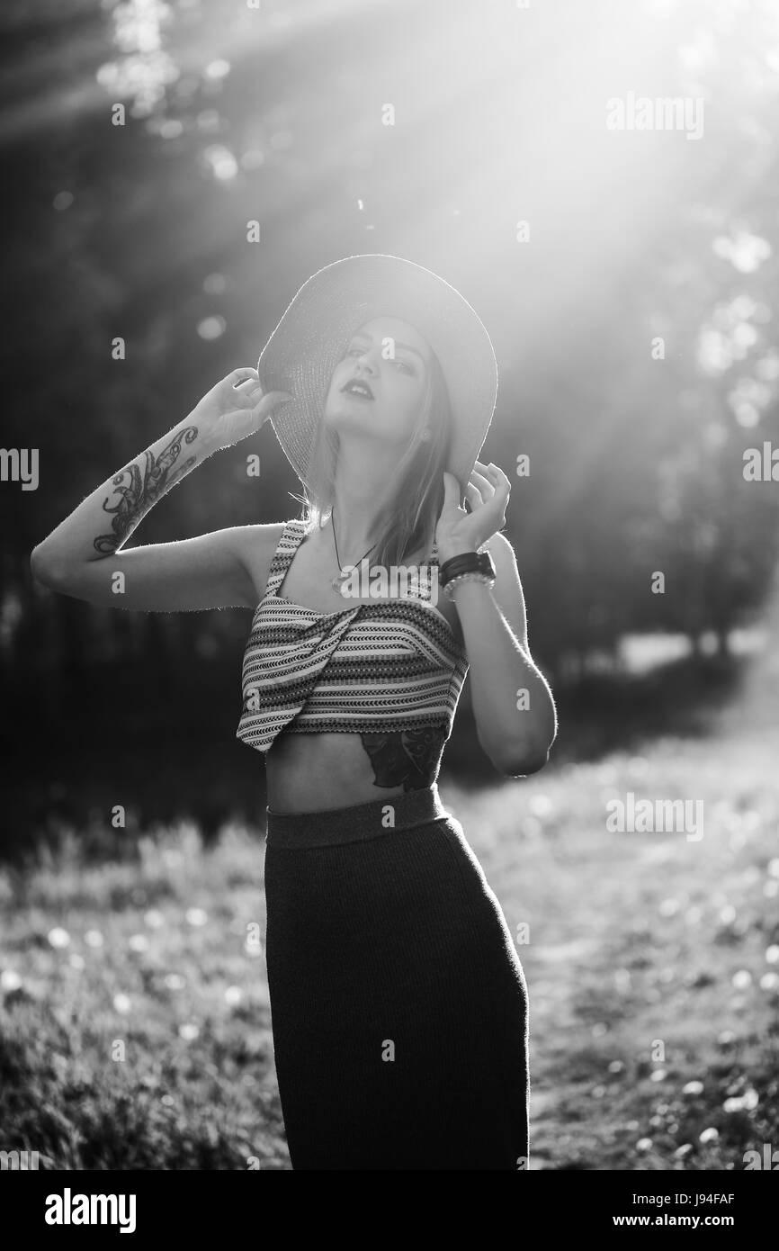 Silhouette de fille qui marche en plein air du parc. Concept de vie d'été ensoleillé. Femme en robe et chapeau dans le champ de pissenlits. Effet de lumière pour le texte. Co Banque D'Images