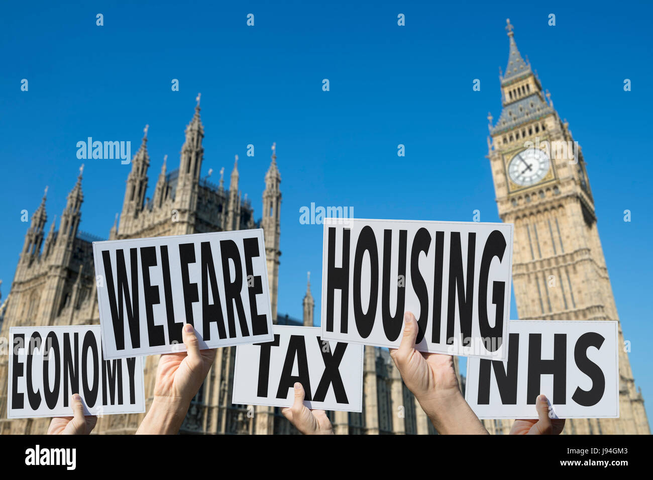 Mains tenant des affiches électorales pour protester contre les problèmes sociaux britannique moderne de l'économie, de fiscalité, de protection sociale, le logement, la santé au Parlement de Westminster Banque D'Images