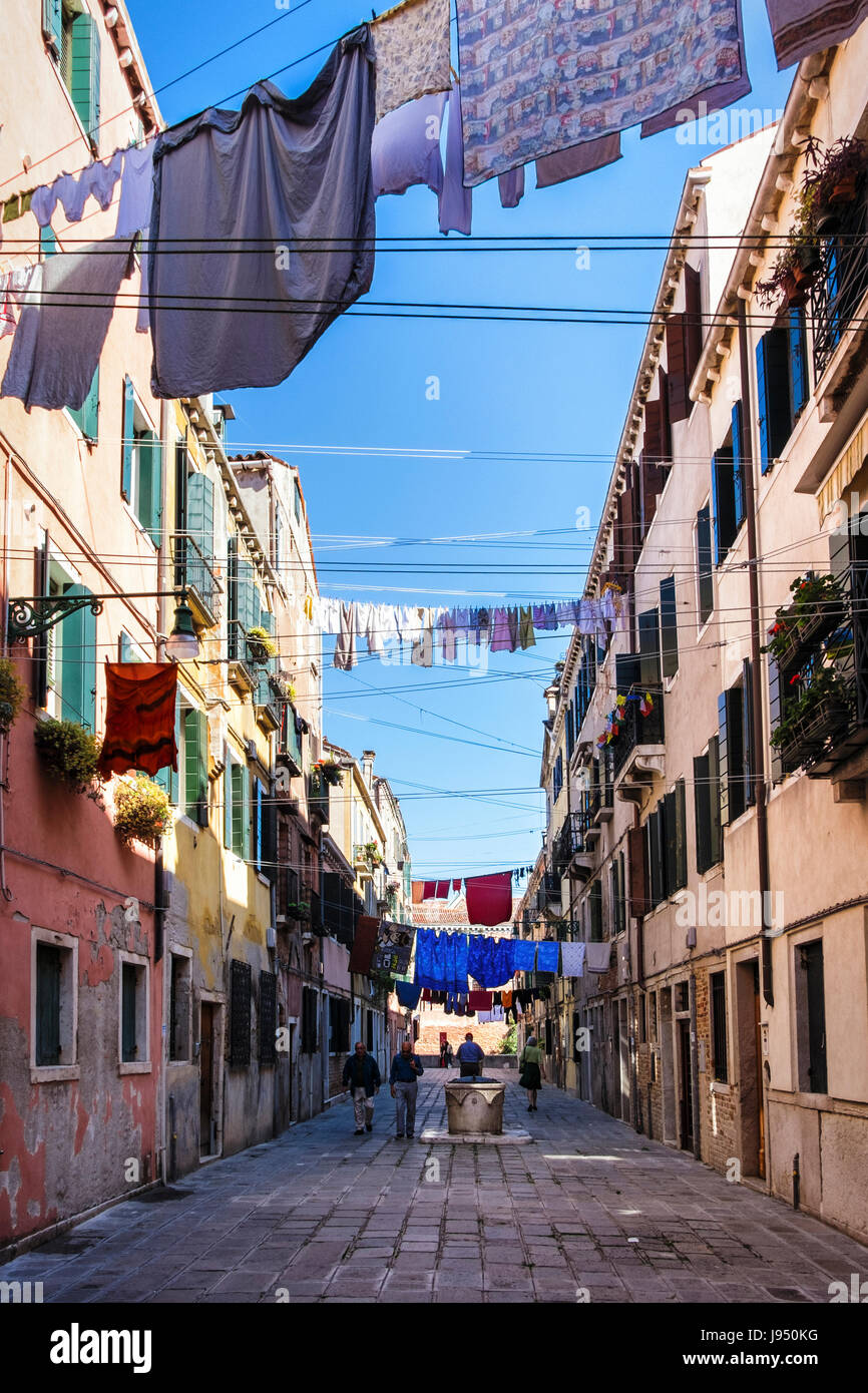 Venise, Castello. Rue étroite avec des maisons pittoresques altérés,ancien puits d'eau, lave-ligne,Jour de lessive et de personnes à pied Banque D'Images