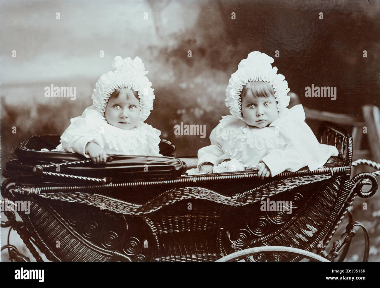 Lits bébé soeurs en Vintage landau, poussette ou Perambulator la période de port de vêtements de bébé et de bonnets c1910 Banque D'Images