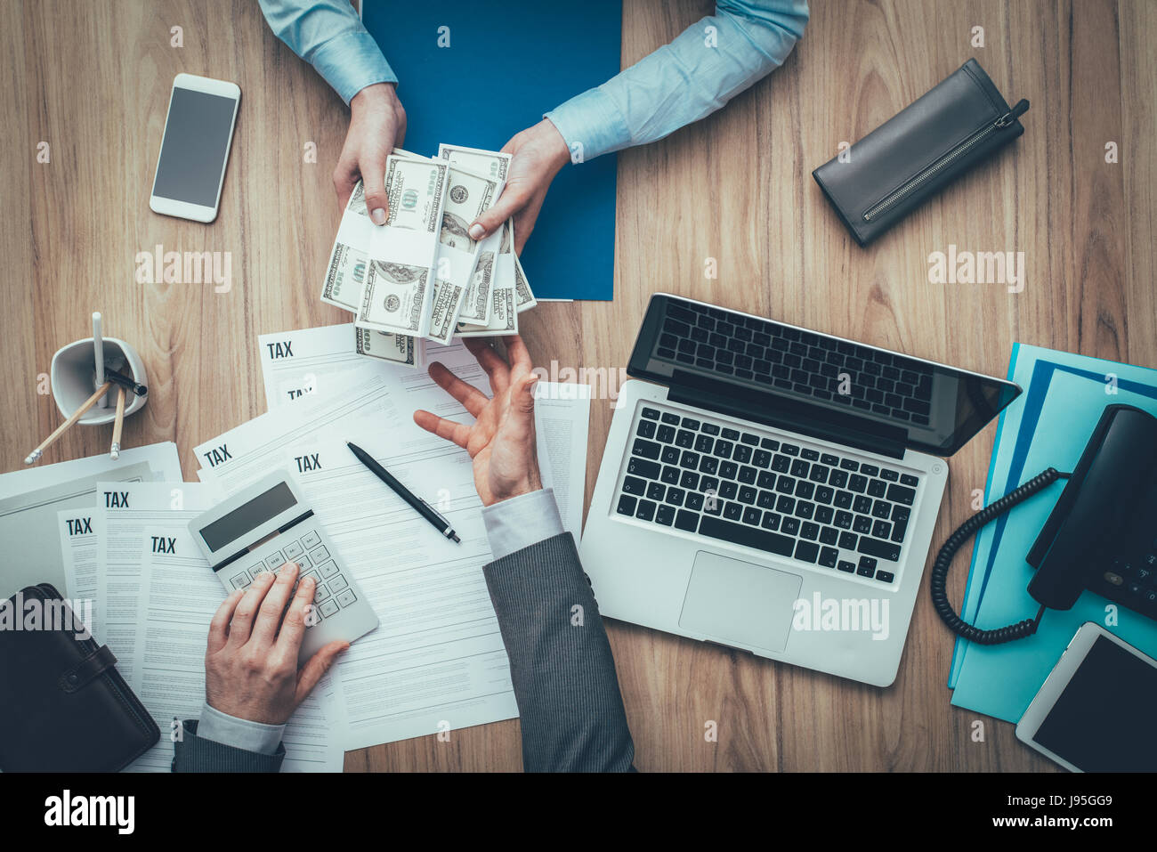 Business Woman giving paquets de dollars à son comptable et de payer des impôts, il est l'examen des formulaires d'impôt et dépenses calcul Banque D'Images