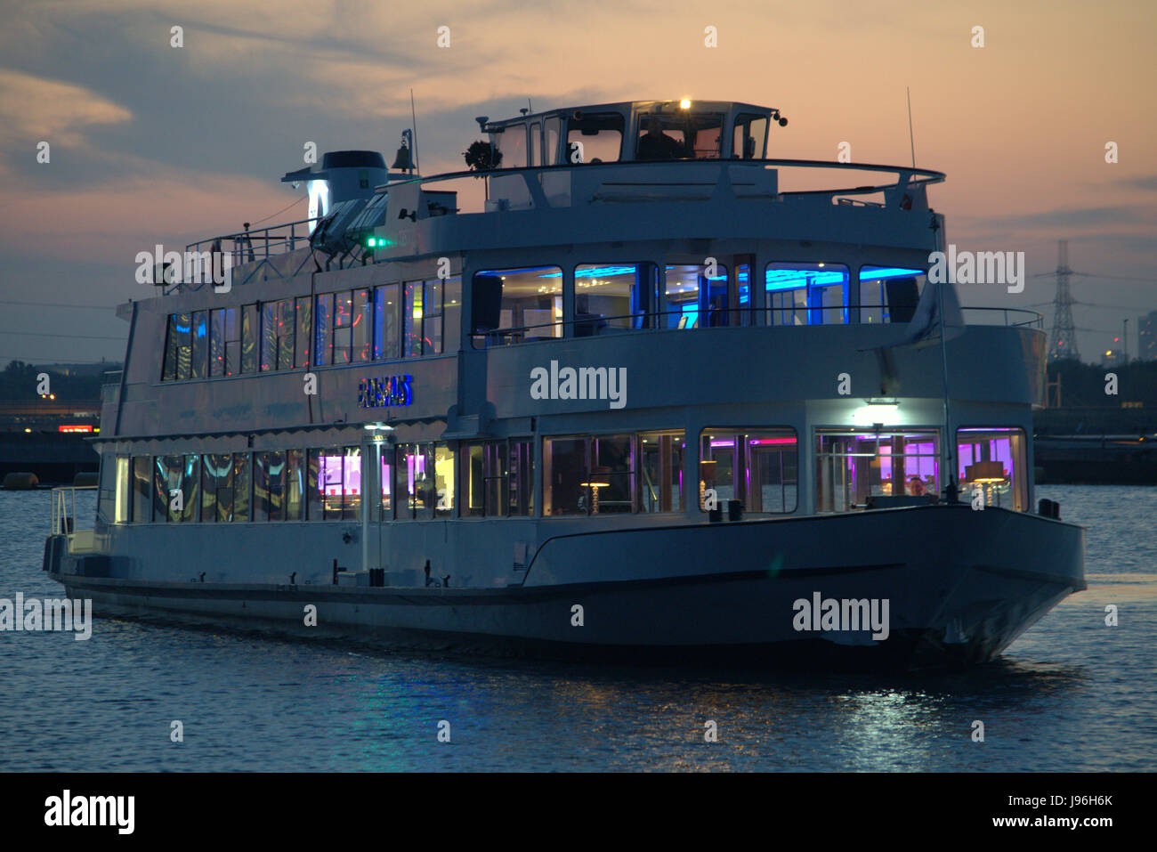 Thames Luxury Charter bateau de partie Erasmus du têtes à travers London's Royal Docks comme la nuit tombe Banque D'Images