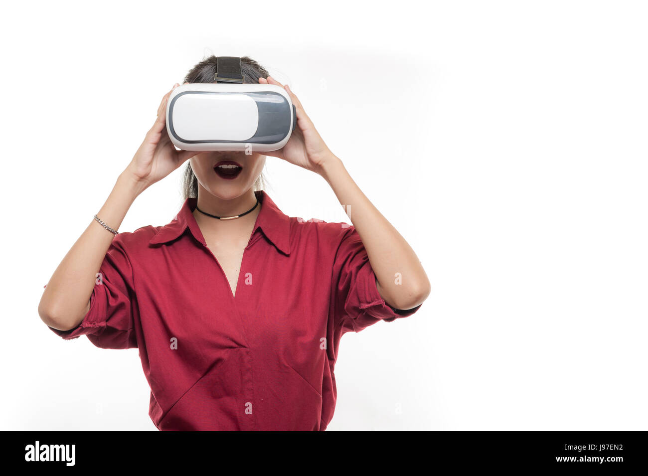 Une scène d'action de Young attractive Asian businesswoman en chemise rouge à l'aide de lunettes VR. L'expérience de réalité virtuelle pour l'activité dans le futur concept development Banque D'Images