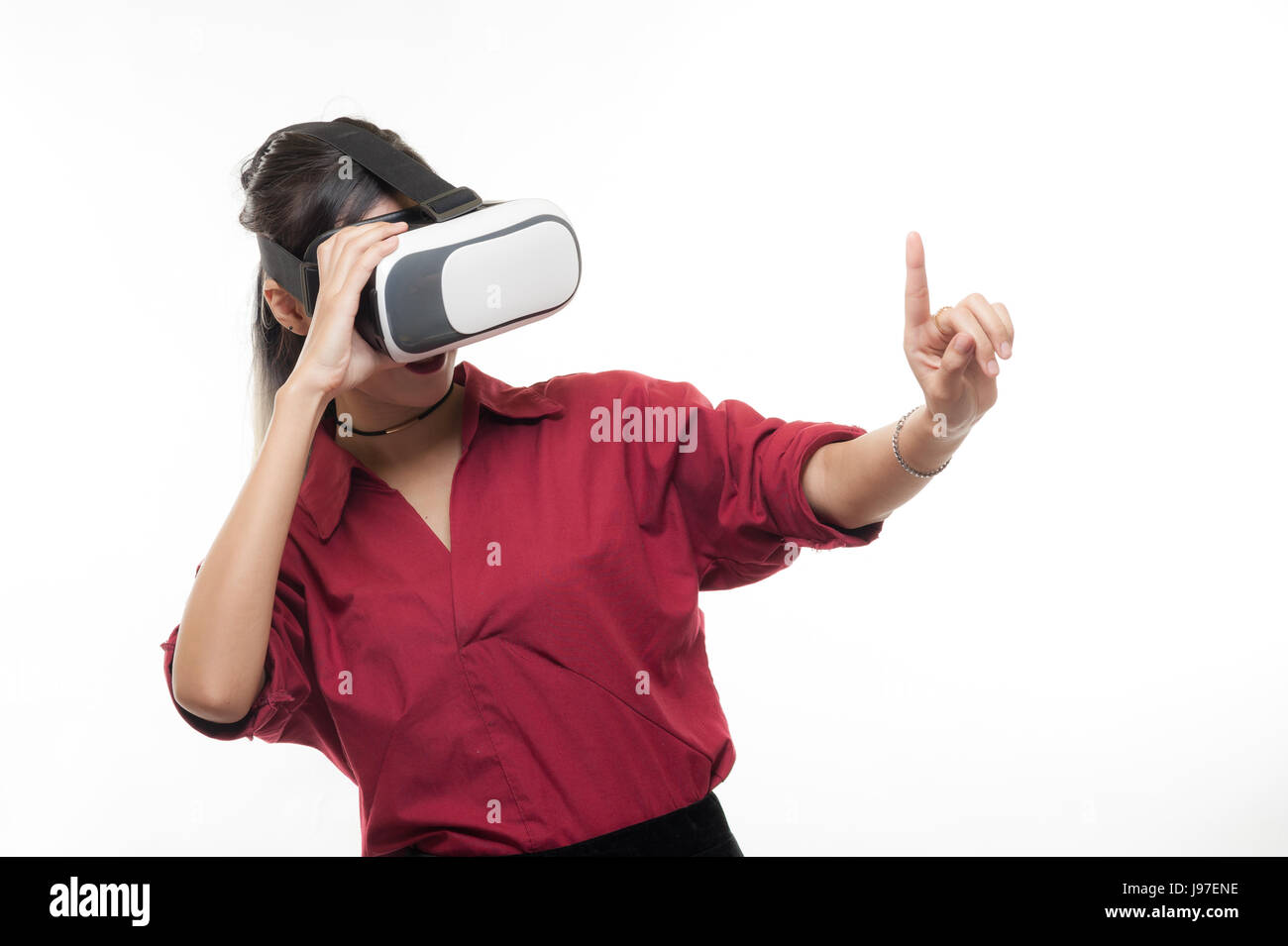 Une scène d'action de Young attractive Asian businesswoman en chemise rouge à l'aide de lunettes VR. L'expérience de réalité virtuelle pour l'activité dans le futur concept development Banque D'Images