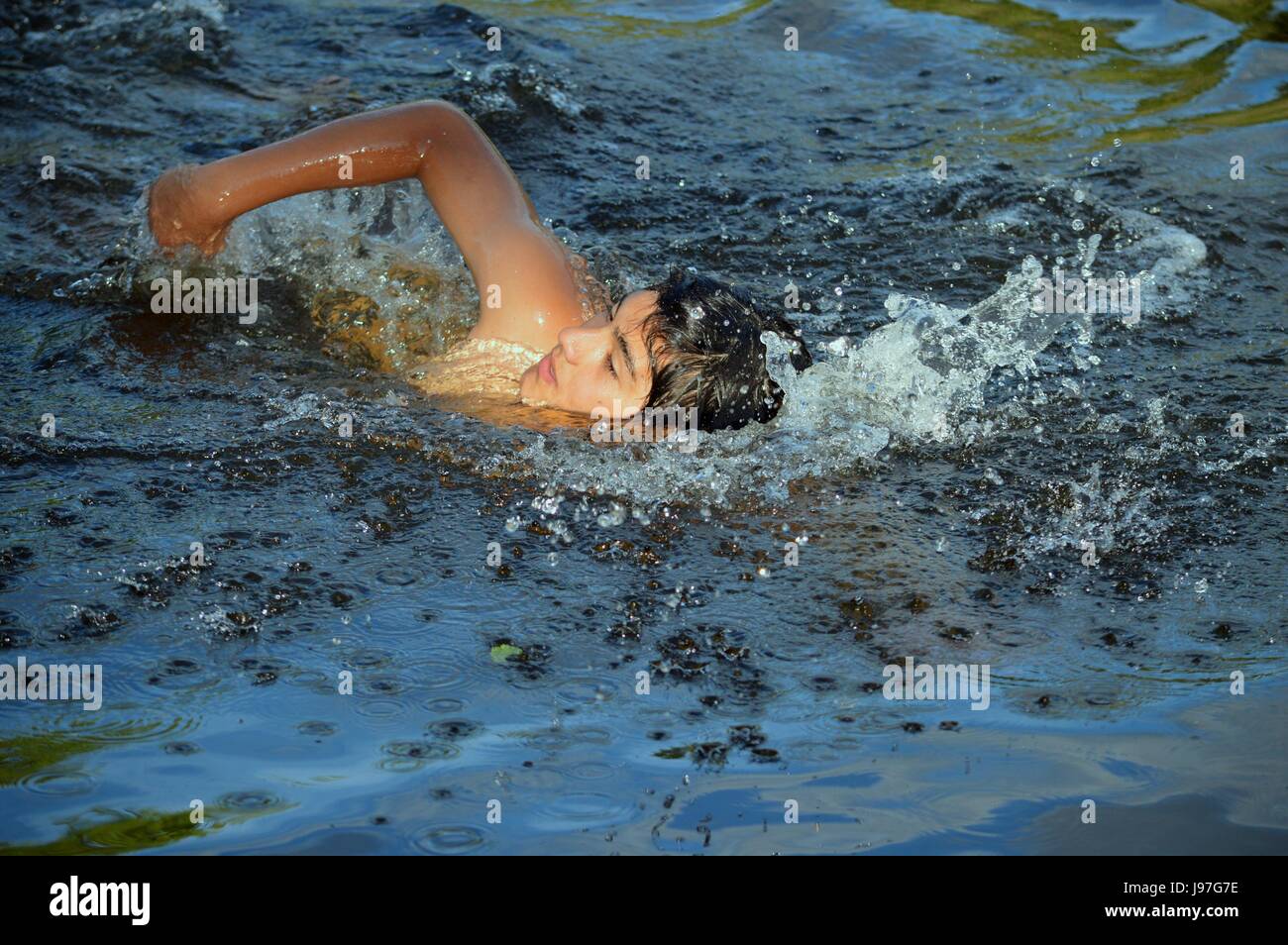 Jeune adolescent nageant dans un lac dans les sierras de Cordoba, La Villa Carlos Paz, Argentine Banque D'Images