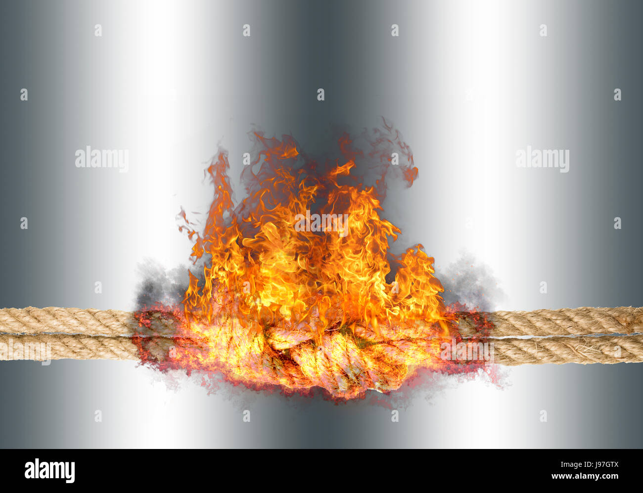 Corde solide avec un noeud, bursted dans des flammes, isolé contre l'arrière-plan de couleur argent Banque D'Images