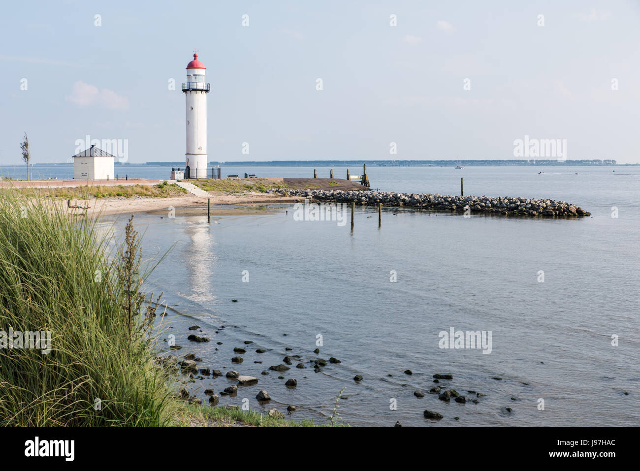 Historique Le phare blanc avec le haut en cuivre rouge caractéristique à la rive de l'Haringvliet à Hellevoetsluis dans le sud-ouest de la Hollande. Banque D'Images