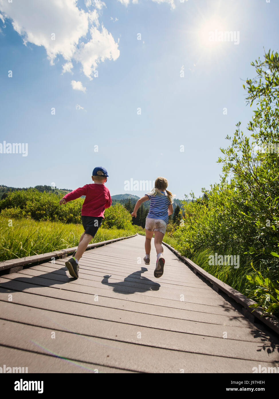 Enfants (4-5) s'exécutant sur boardwalk Banque D'Images