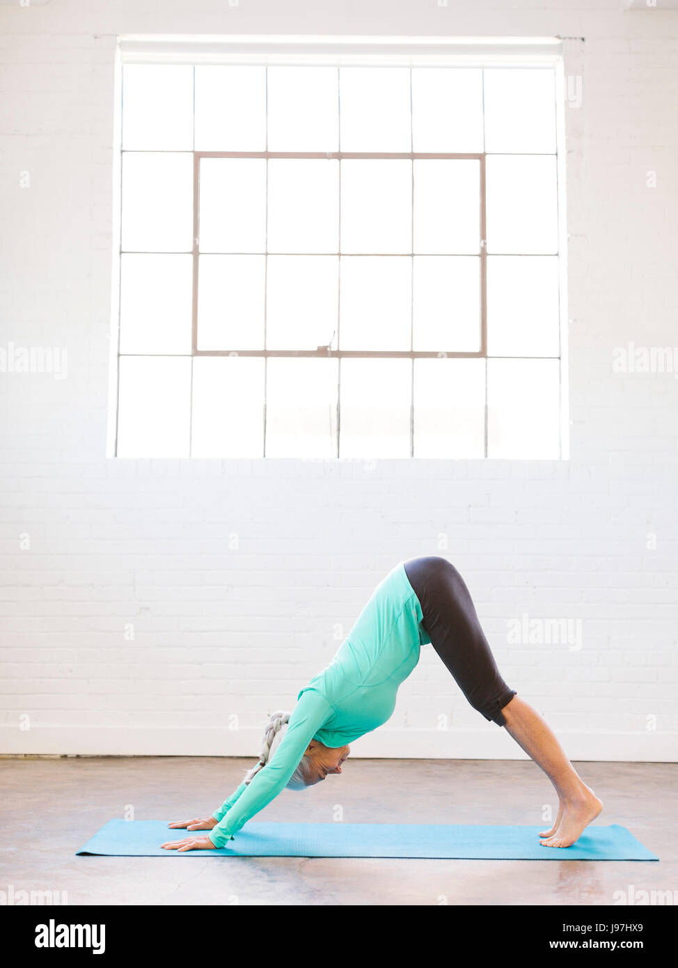 Senior woman practicing yoga on mat Banque D'Images