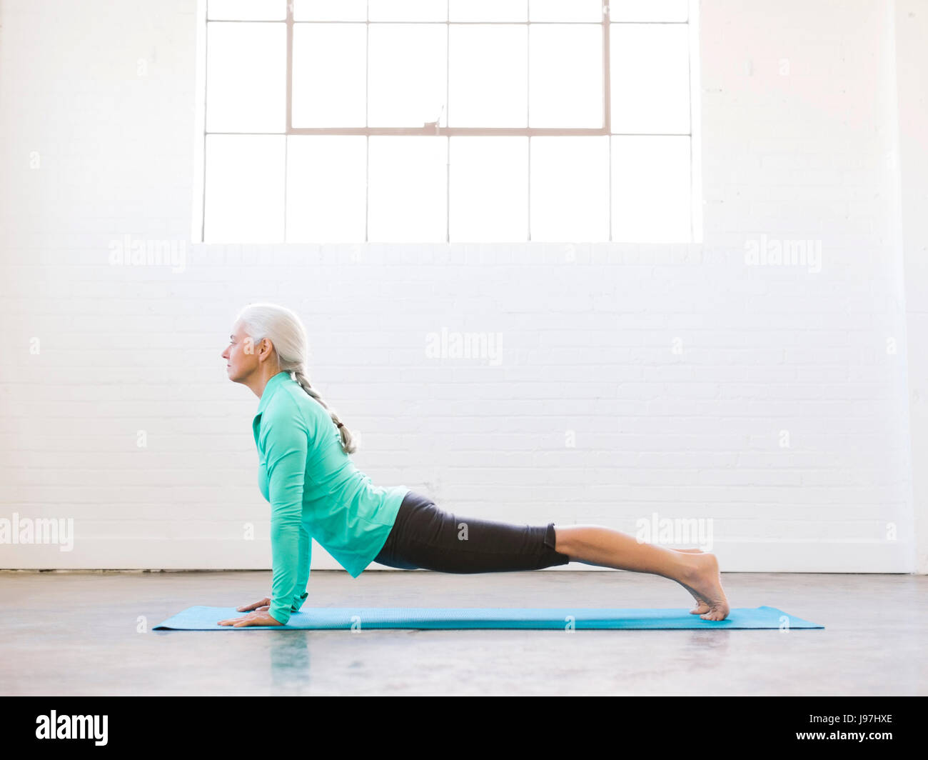 Senior woman practicing yoga on mat Banque D'Images
