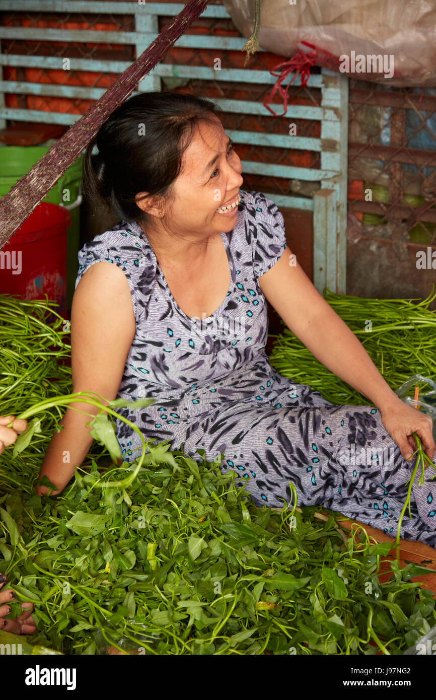 Femme avec produire peut caler au marché Duoc, Province de Long An, Delta du Mekong, Vietnam Banque D'Images