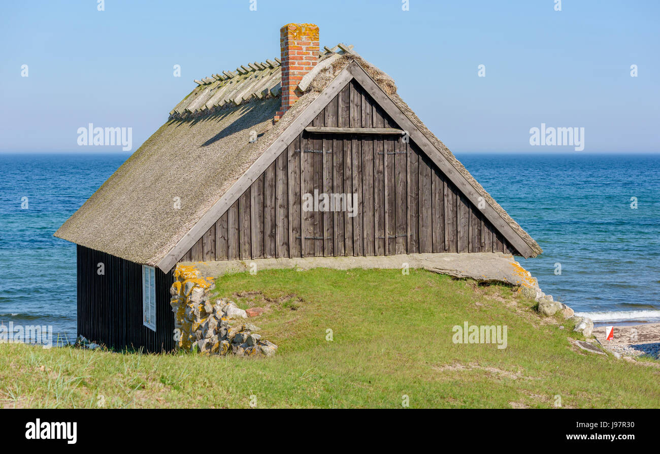 Havang réserve naturelle, Suède - Mai 18, 2017 : l'environnement documentaire. Vieux chalet de pêche et noir avec toit de chaume et de la cheminée, à côté de la plage de sable Banque D'Images