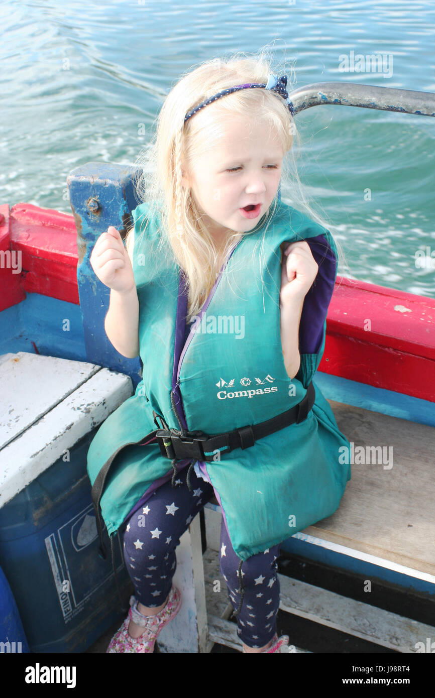 Enfant portant un gilet,s'amusant sur un voyage en bateau dans la baie de Dublin, Irlande Banque D'Images