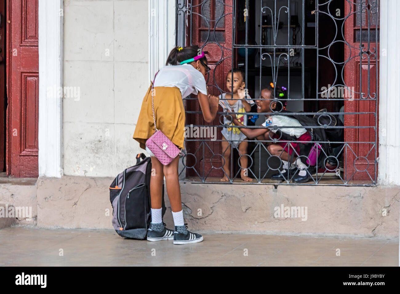 Fille de l'école dit bonjour à quelques jeunes amis - Cienfuegos, Cuba Banque D'Images