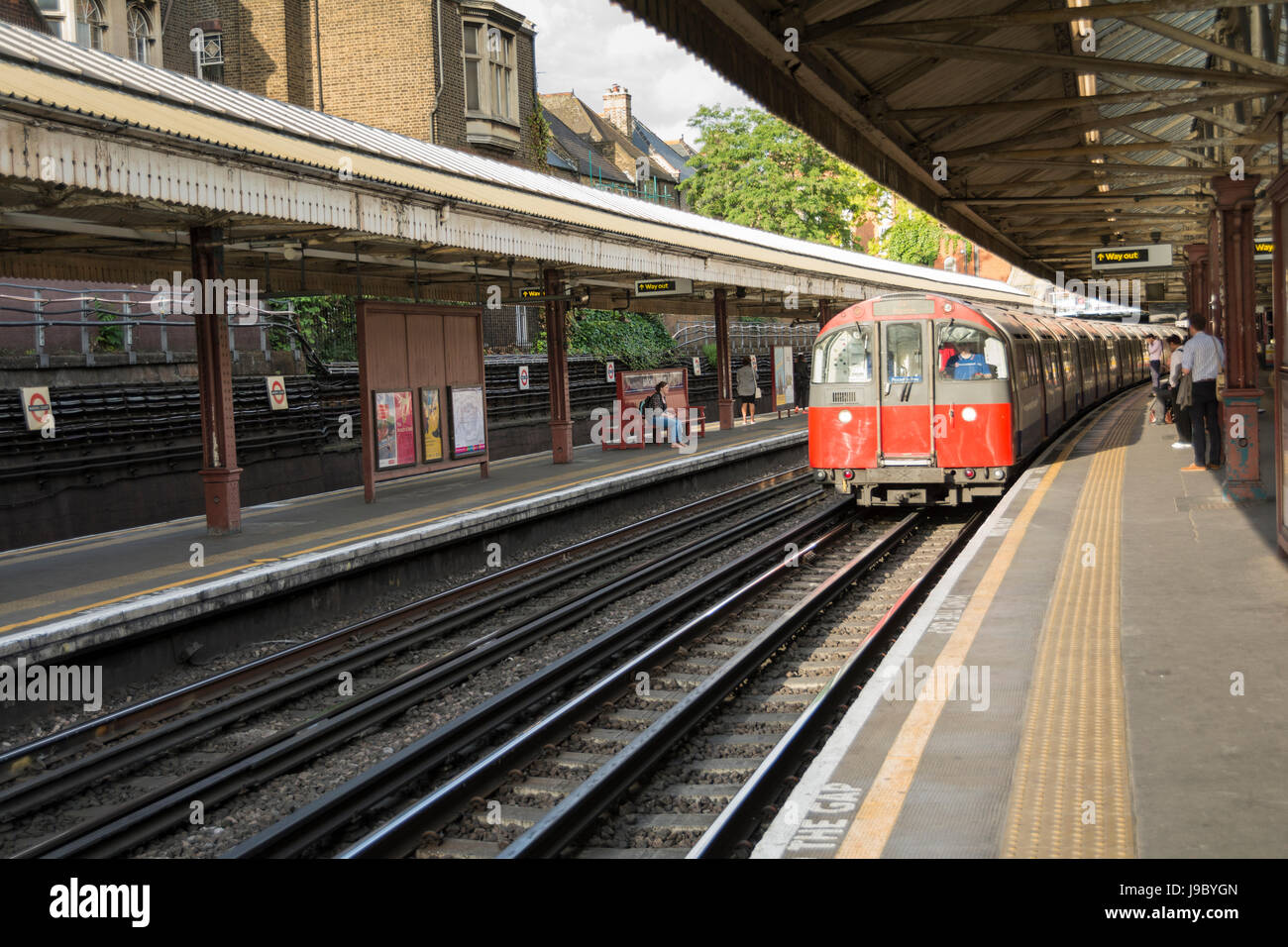 La ligne Piccadilly train tirant en Barons Court tube station sur la ligne Piccadilly et District, London, UK Banque D'Images