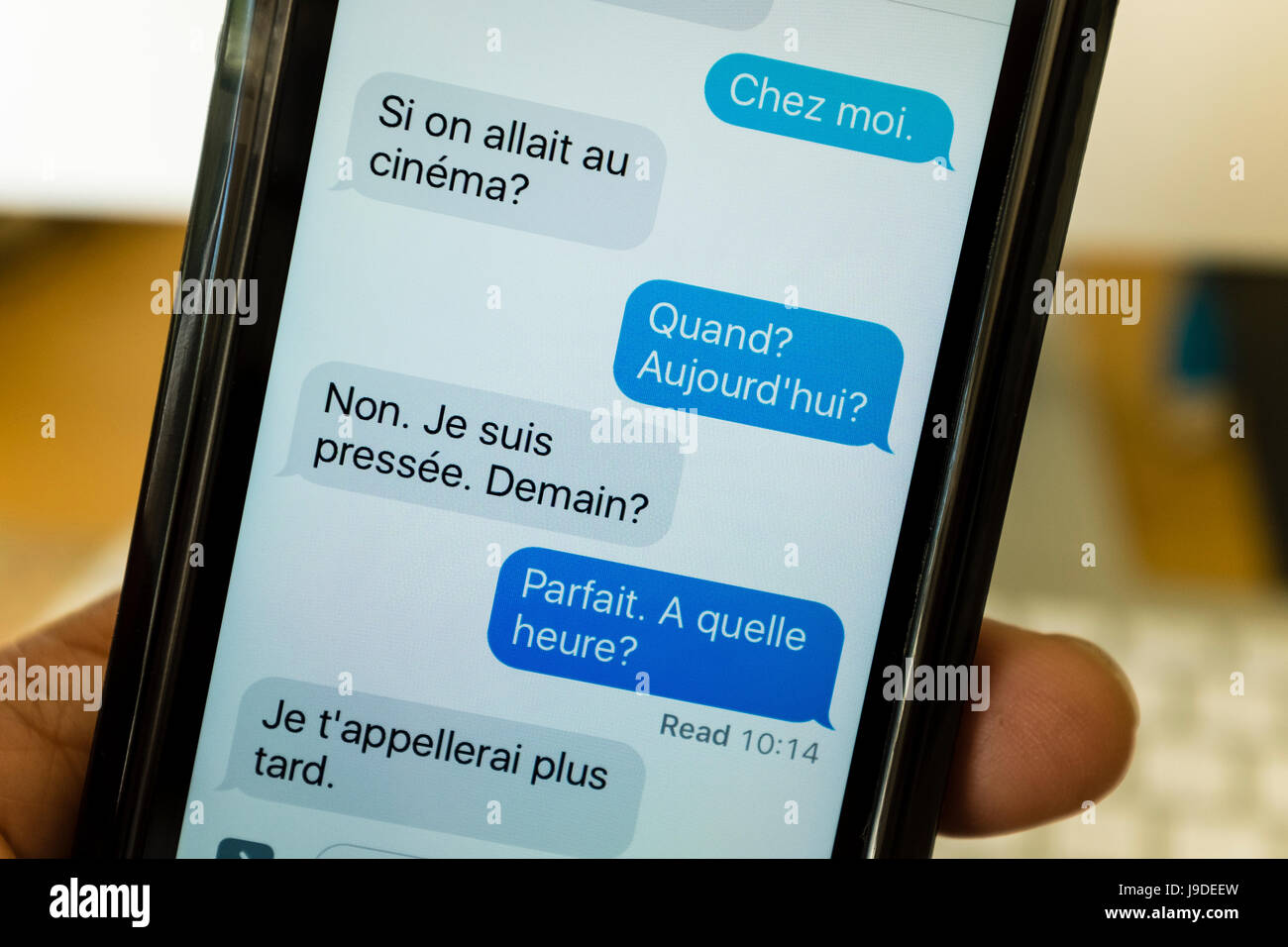 Messages texte écrit en français sur un smartphone Banque D'Images