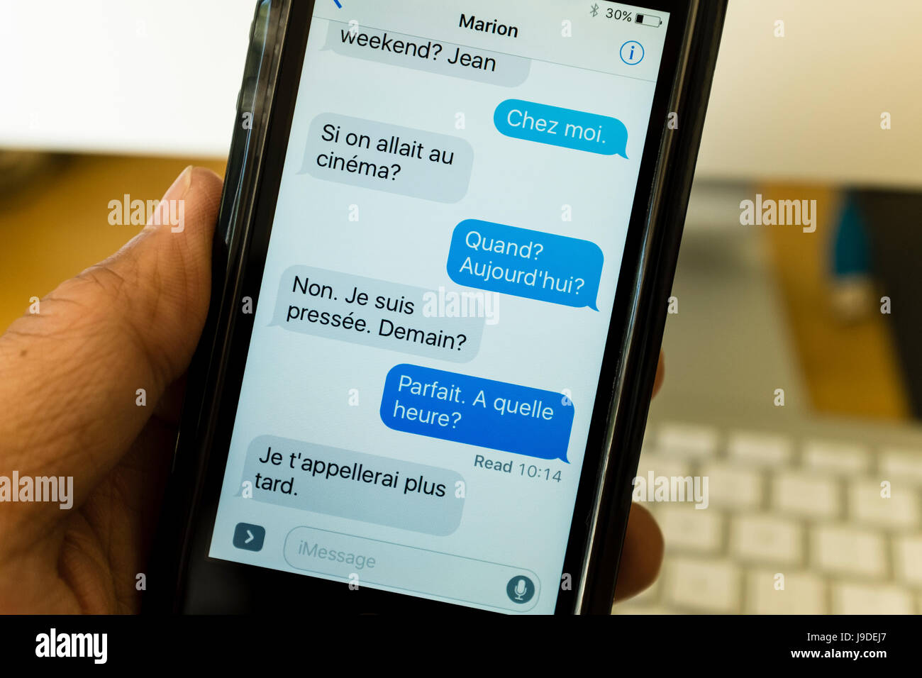 Messages texte écrit en français sur un smartphone Banque D'Images