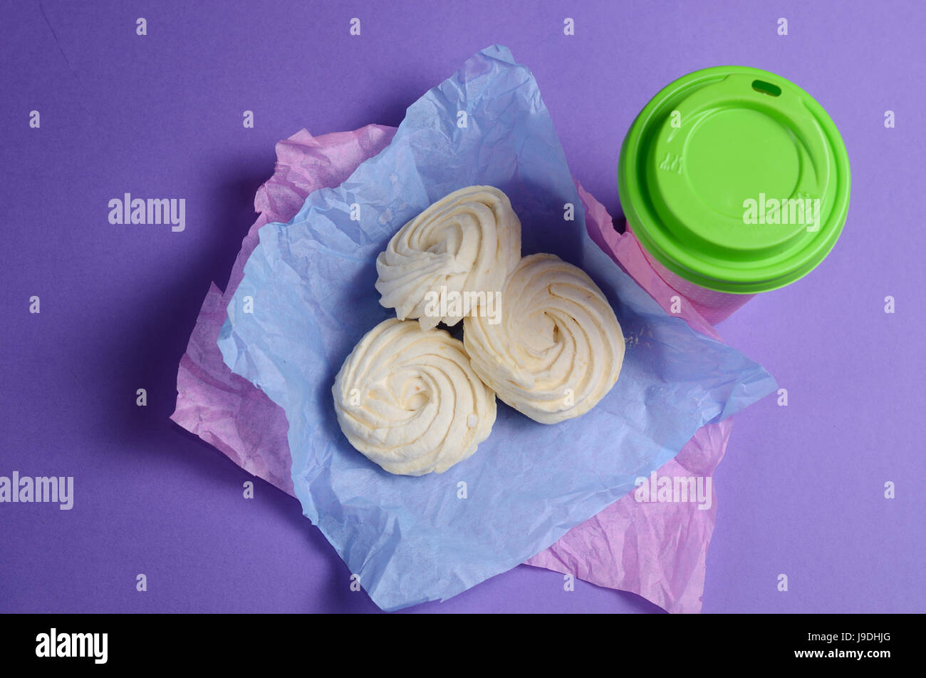 Photo alimentaire composé de Zéphyr, marshmallow en violet, du papier d'emballage et de la coupe du café à emporter. Banque D'Images