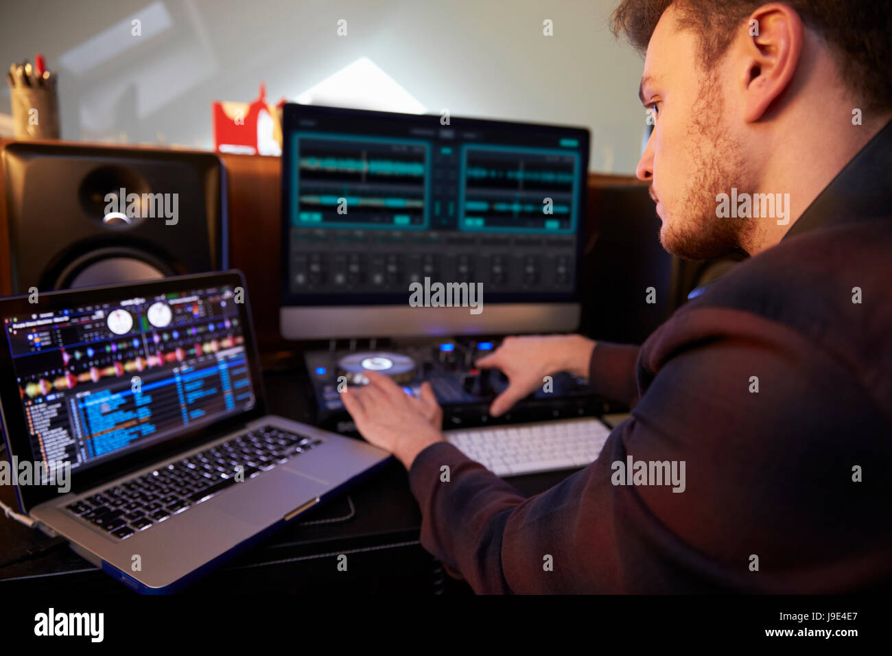 Jeune homme de composer la musique sur un ordinateur portable dans la  chambre Photo Stock - Alamy