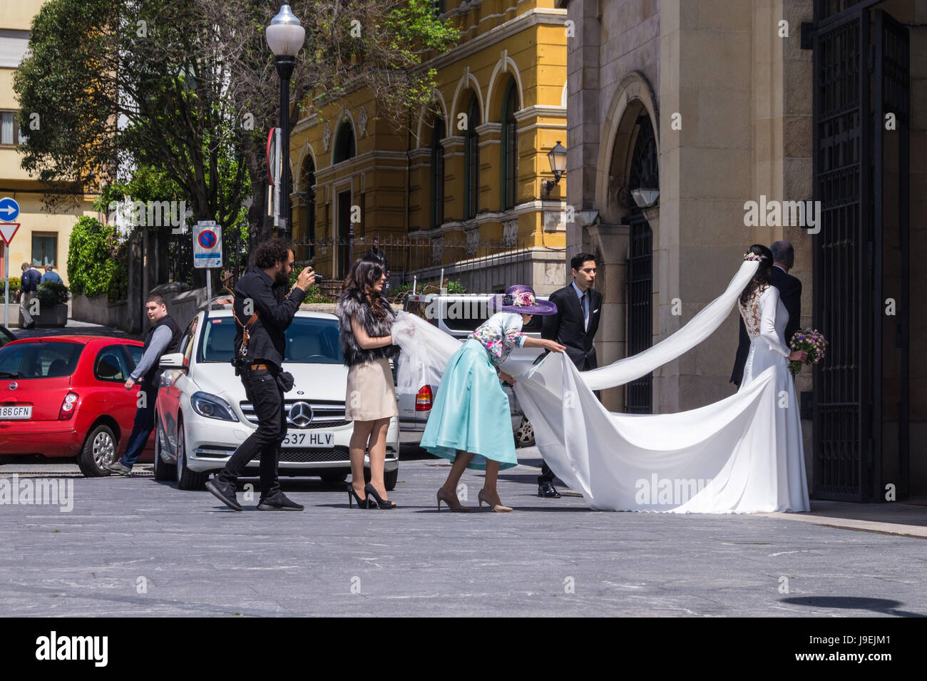 Un photographe de mariage avec mariée, marié et fête de mariage à l'extérieur de l'église San Pedro, Gijon Asturias Espagne Banque D'Images