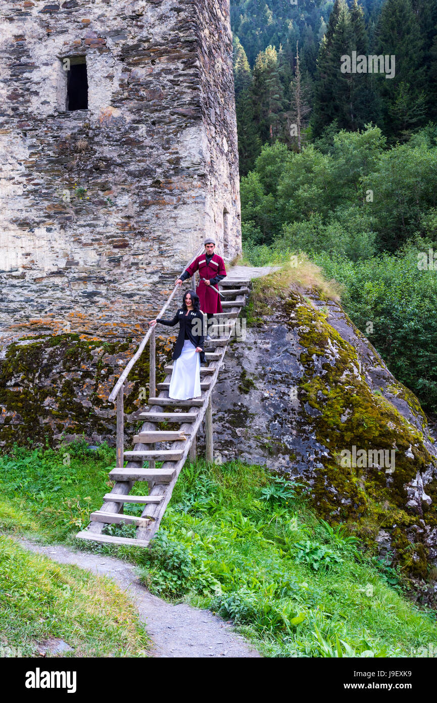 Couple en costume traditionnel géorgien en ordre décroissant des escaliers de la tour de l'amour, pour un usage éditorial uniquement, Ushguli, région de Svaneti, Géorgie Banque D'Images