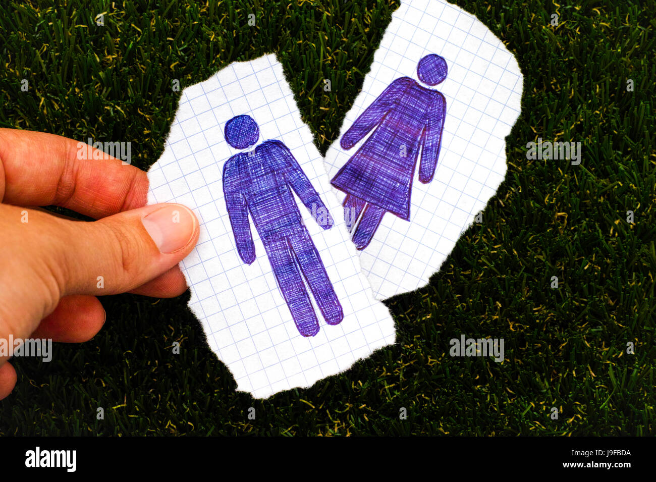 Personne doigts holding feuille de papier, l'homme figure à la main. Autre  feuille de papier, appelée femme figure sur fond d'herbe. Doodle style  Photo Stock - Alamy
