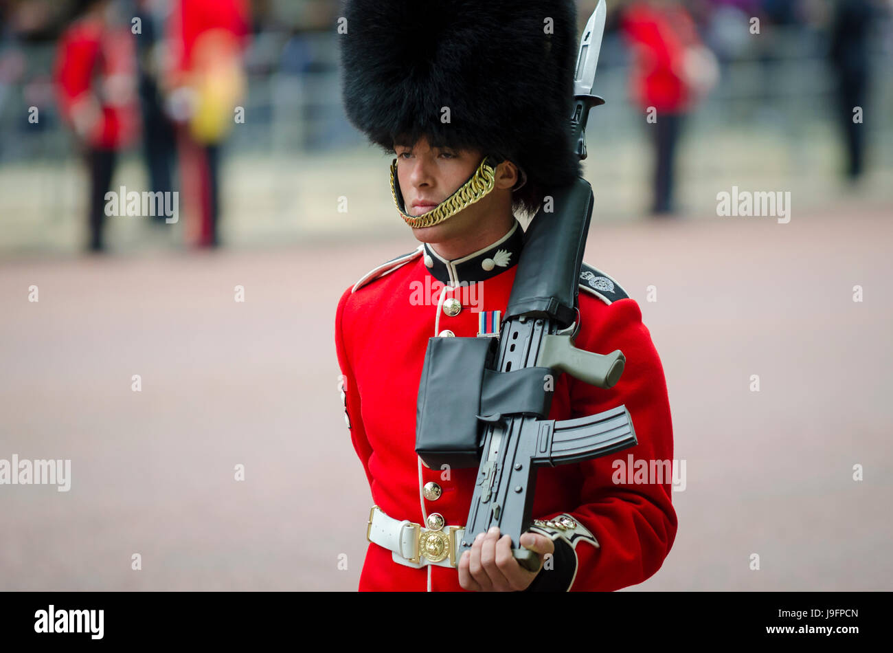 Londres - le 13 juin 2015 : garde royale dans un manteau rouge en fourrure  d'ours et busby hat se dresse sur le Mall avec fusil en une parade la  couleur célébration