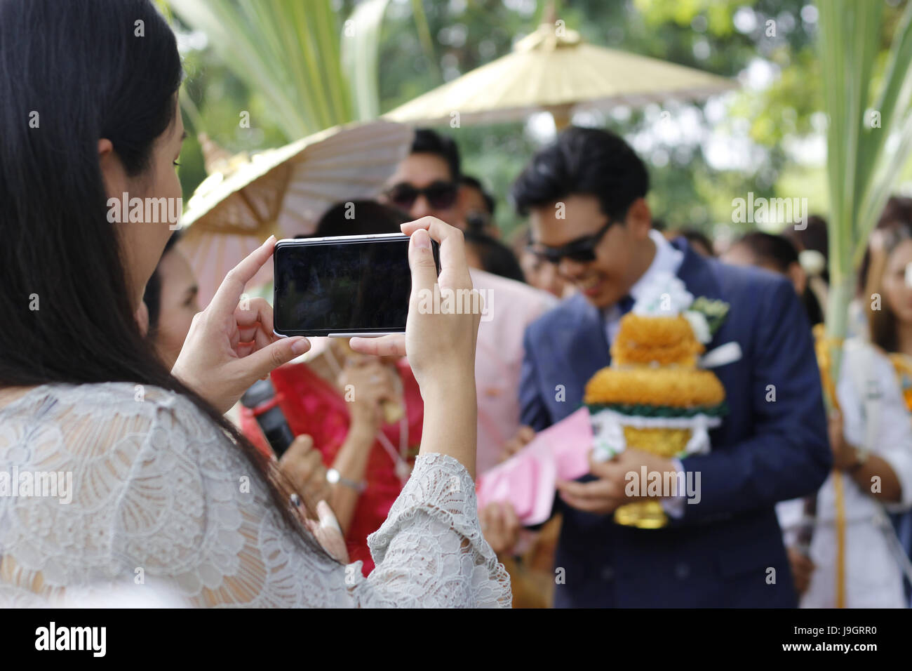 Close up of woman téléphone part prendre une photo de la cérémonie du mariage tradition thaïlandaise Banque D'Images