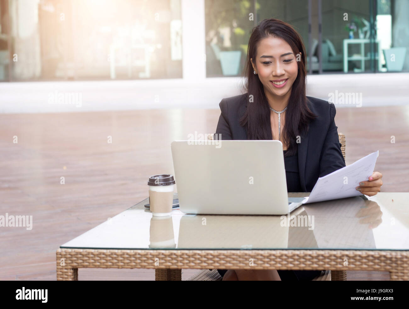 Madame asiatique businesswoman entrepreneur journée bien remplie avec un ordinateur portable dans l'air extérieur Lieu historique avec flare light Banque D'Images