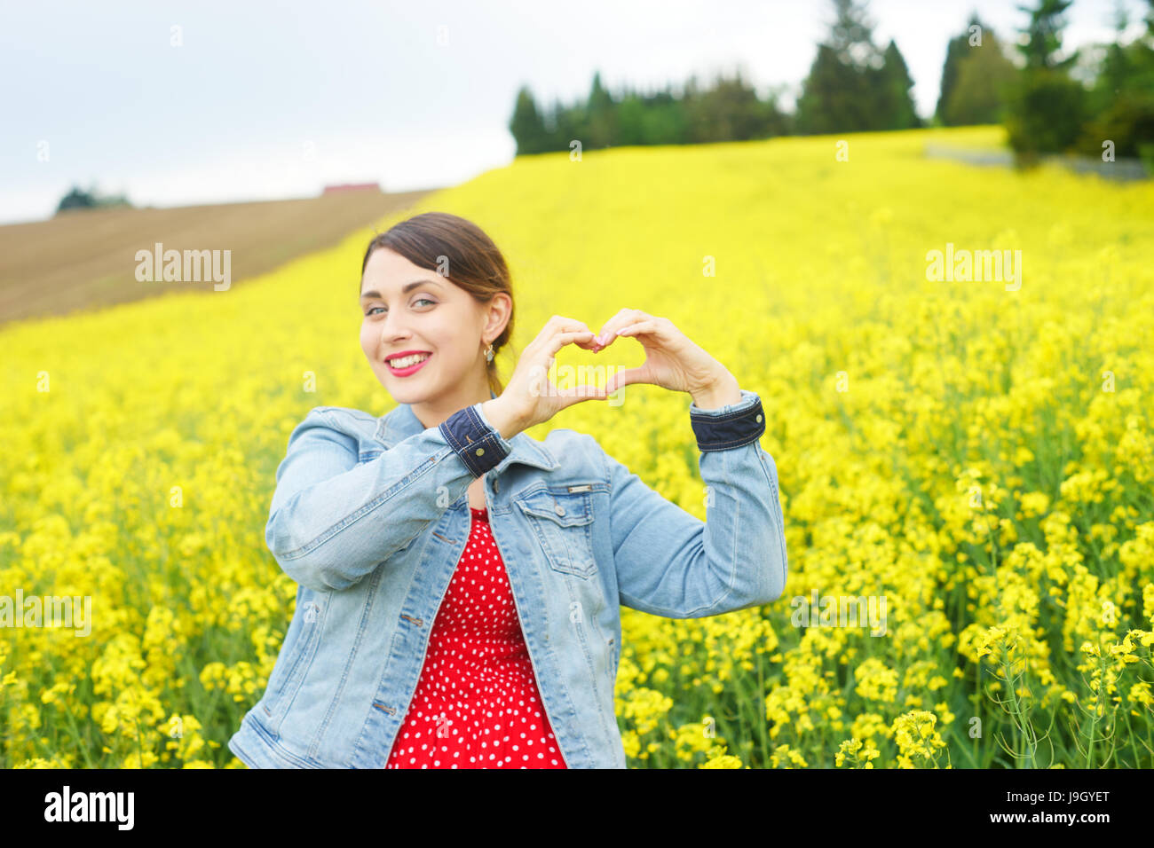 Une jeune femme en champ de colza. Banque D'Images