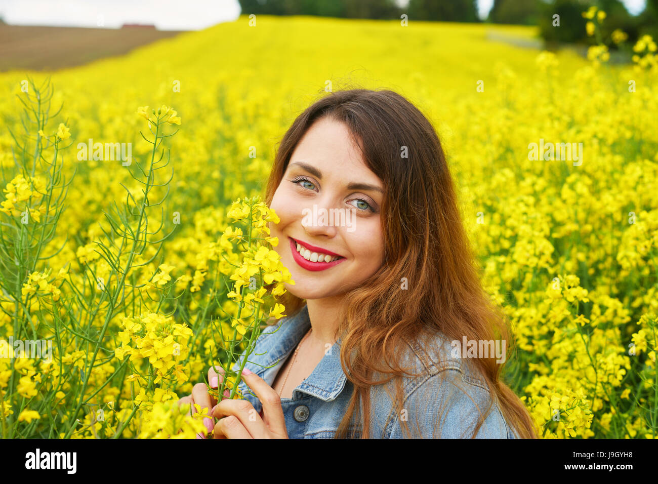 Une jeune femme de race blanche dans le champ de colza Banque D'Images