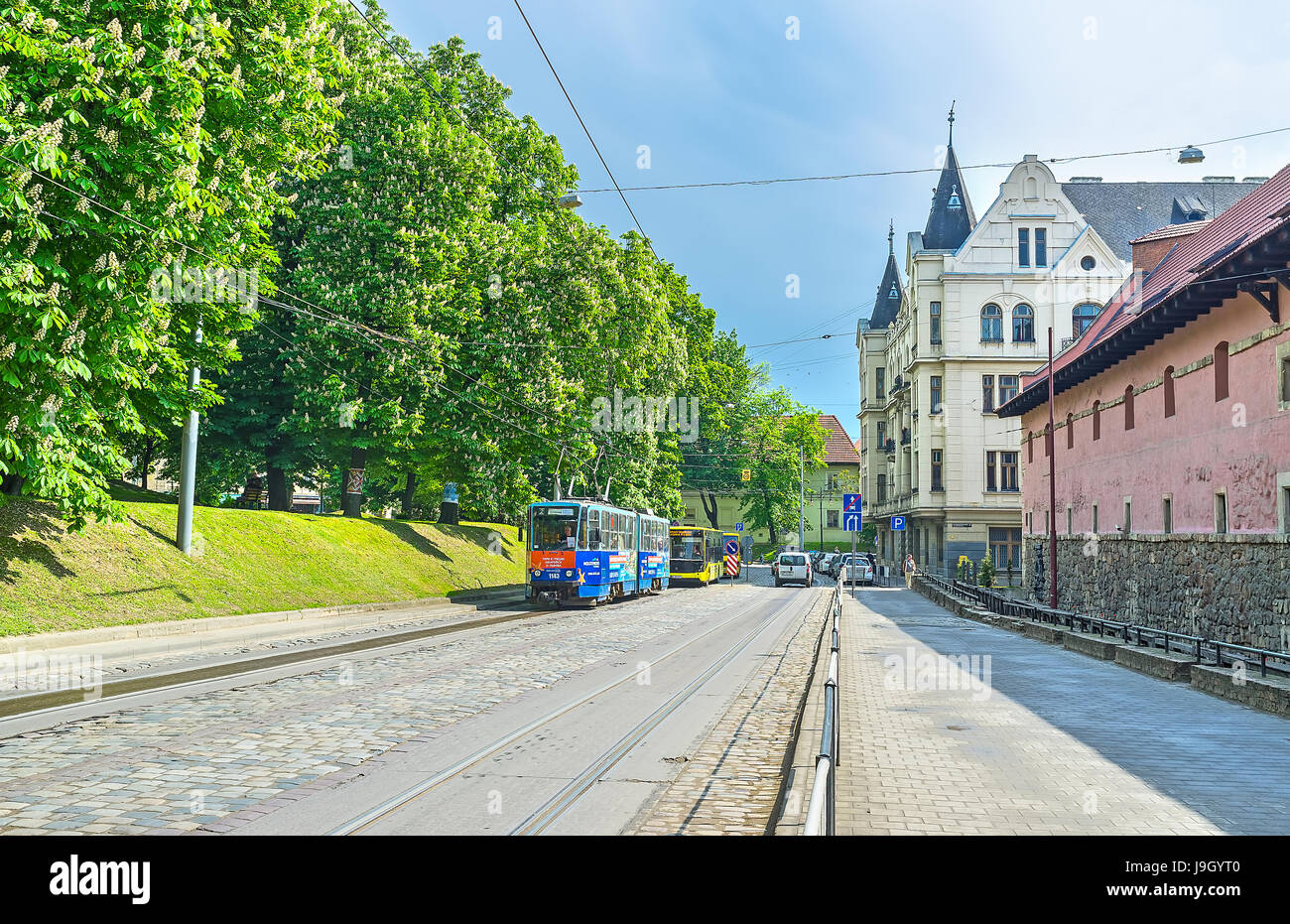 LVIV, UKRAINE - 16 MAI 2017 : rue Pidvalna avec le vieux mur de la ville Arsenal et les châtaigniers en fleurs du jardin public sur les remparts Banque D'Images