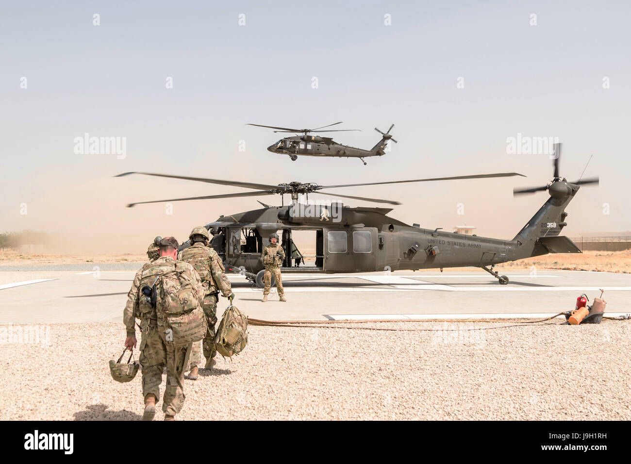 L'ARMÉE AMÉRICAINE UN UH-60 Black Hawk chef d'équipage assigné à la Force Griffin, 16e Brigade d'aviation de combat, de guider les passagers au cours du chargement 31 Mai, 2017 à Kunduz, Afghanistan. Kunduz a vu le renforcement de l'activité des talibans comme plus de 8 000 et 6 000 soldats américains de l'OTAN et des pays alliés continuent d'aider le gouvernement. Banque D'Images
