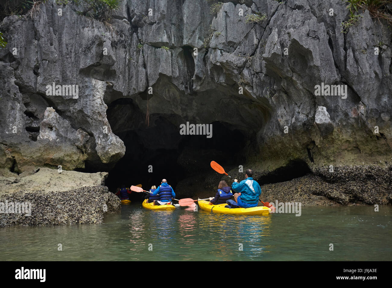 Les kayakistes et mer agitée, Ha Long Bay (site du patrimoine mondial de l'Unesco ), Province de Quang Ninh, Vietnam Banque D'Images