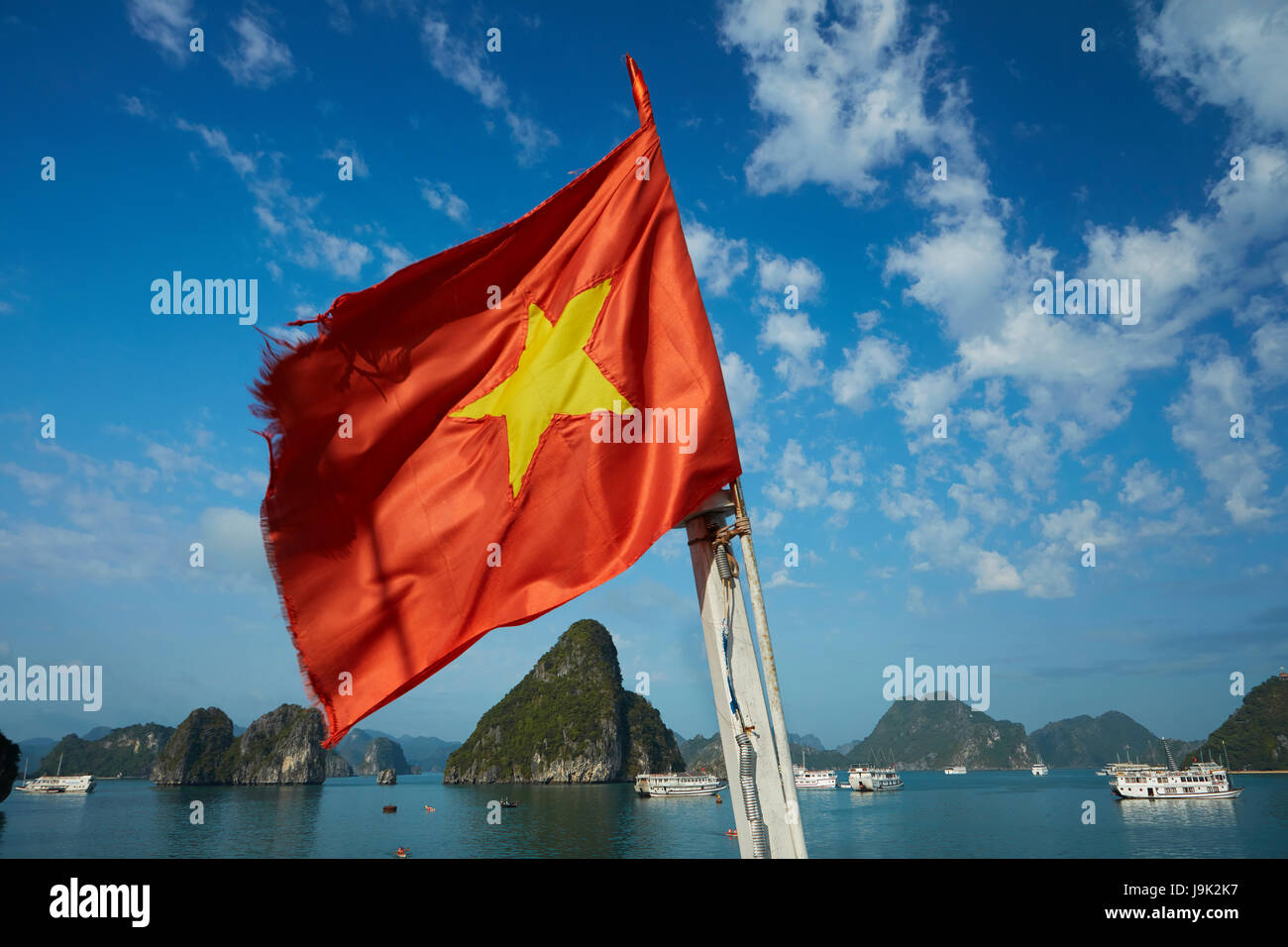 Drapeau vietnamien sur bateau de tourisme et de calcaire karst, Ha Long Bay (site du patrimoine mondial de l'Unesco ), Province de Quang Ninh, Vietnam Banque D'Images