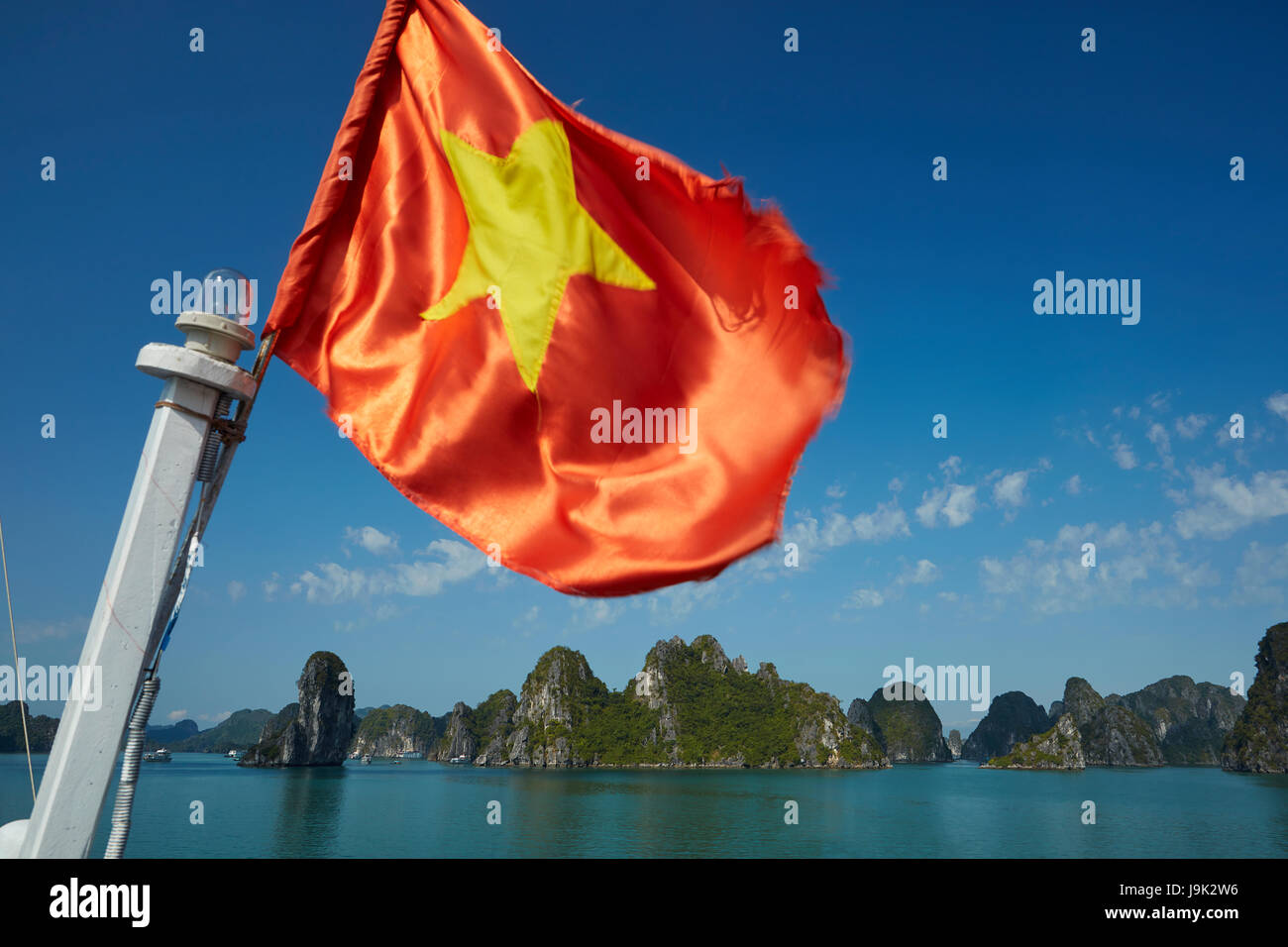 Drapeau vietnamien sur bateau de tourisme et de calcaire karst, Ha Long Bay (site du patrimoine mondial de l'Unesco ), Province de Quang Ninh, Vietnam Banque D'Images