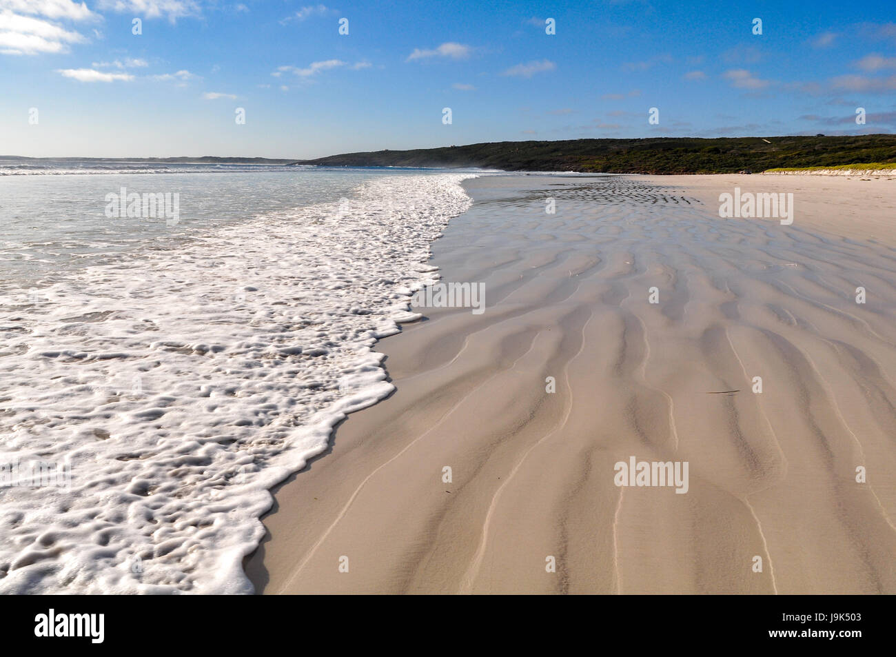 Belle plage de sable blanc avec petite vague de rupture dans un paysage naturel. Banque D'Images