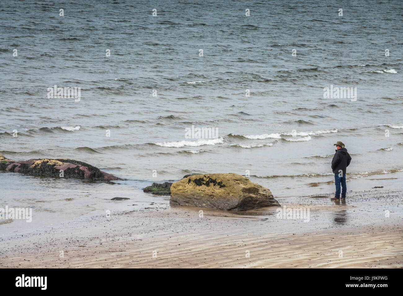Waterville, Irlande - Avril 2017 : homme debout sur le bord de la mer dans Ballingskelligs Bay Beach, Waterville, dans le comté de Kerry, Irlande Banque D'Images