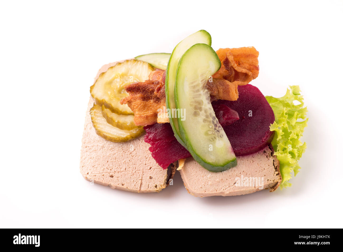 Des plats nationaux et des spécialités danoises, sandwich ouvert de grande qualité, le pâté de foie avec du bacon, betterave cornichon et concombre isolated on white ba Banque D'Images