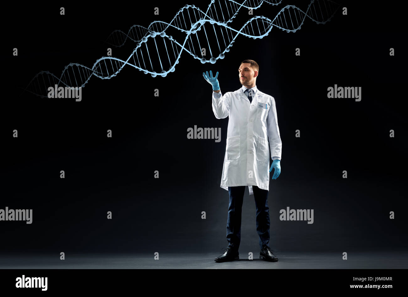 Scientifique en blouse blanche et gants médicaux avec de l'adn Banque D'Images