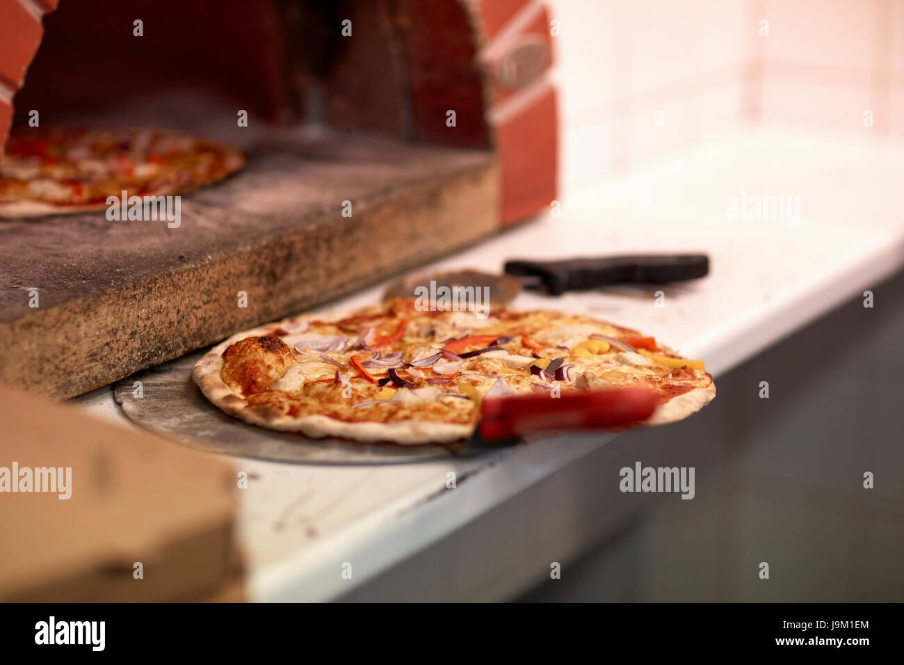 Sur pizza cuite au four peler et pizzeria Banque D'Images Sur pizza cuite au four peler et pizzeria Banque D'Images