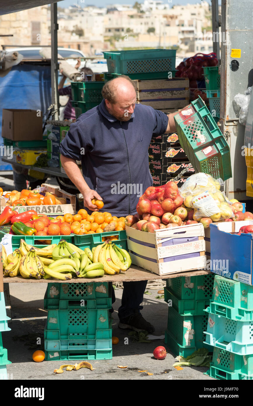 Un commerçant du marché sur un marché de fruits et légumes au marché à Marsaxlokk Malte Banque D'Images