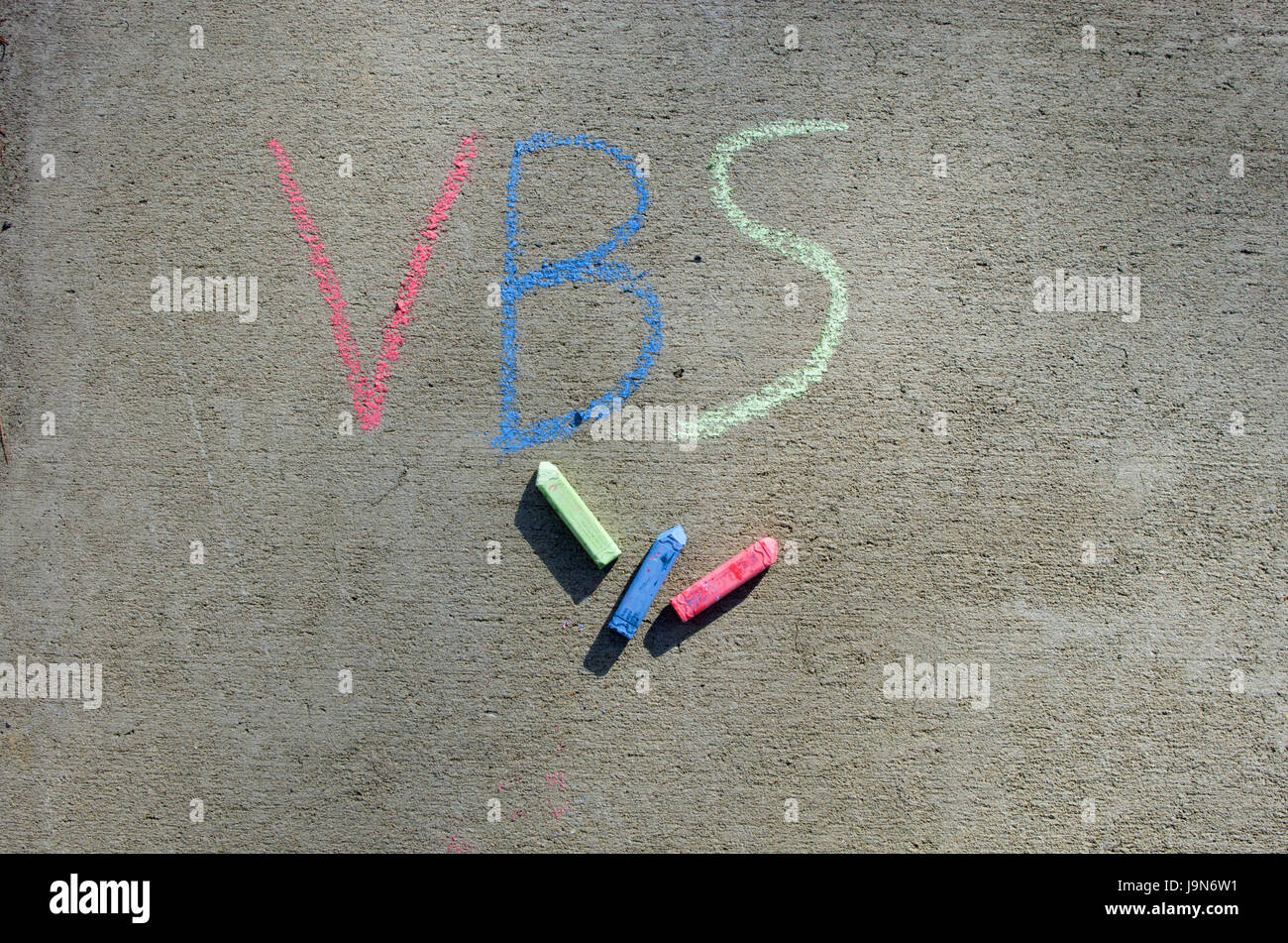 VBS écrit sur trottoir en craie coloré avec de la craie dispersés dans l'image Banque D'Images