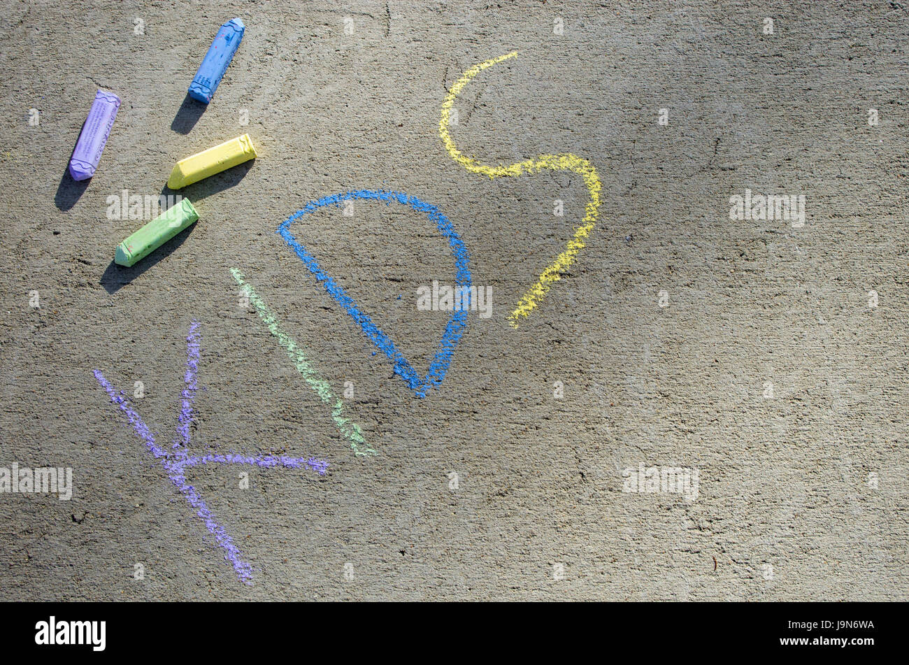 Enfants grand écrit sur trottoir en craie coloré avec de la craie dispersés dans l'image Banque D'Images