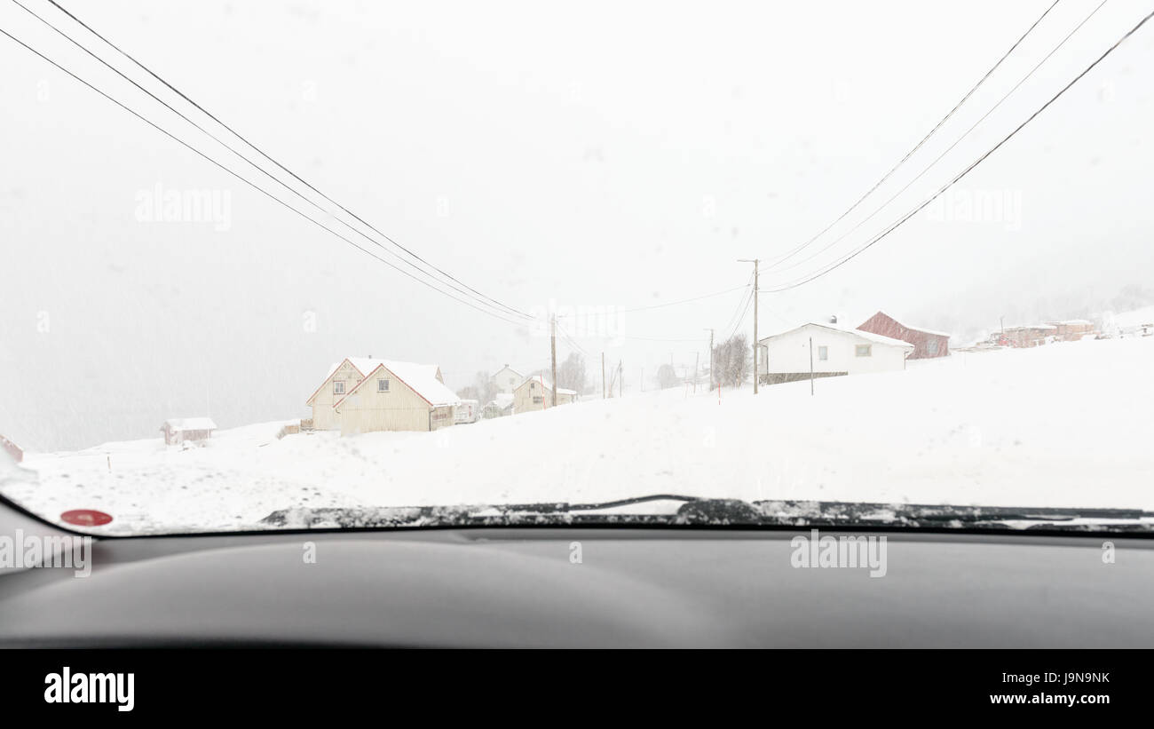 Une route d'hiver un jour avec de fortes chutes de neige et presque pas de site de l'avant. Photo prise à travers un pare-brise de voiture. Straumsbukta, Kvaløya, Tromsø, Norvège. Banque D'Images